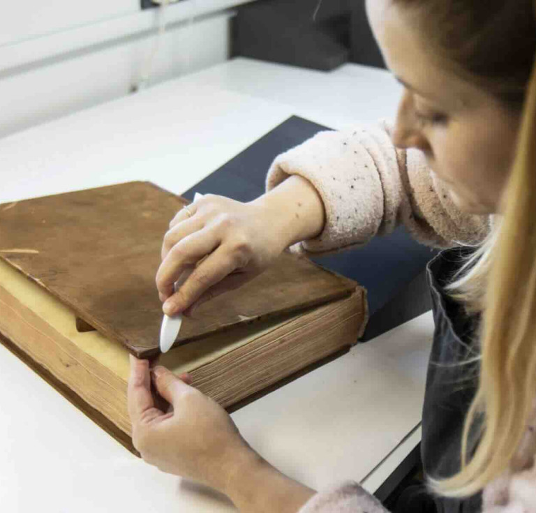Paper conservator Jen Snowden working on Francis Austen’s mathematics coursebook from the Royal Naval Academy at Portsmouth.